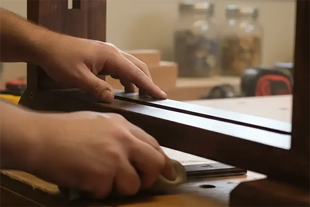 Craftsman working on a wooden display stand in the StandCraft Canada workshop.