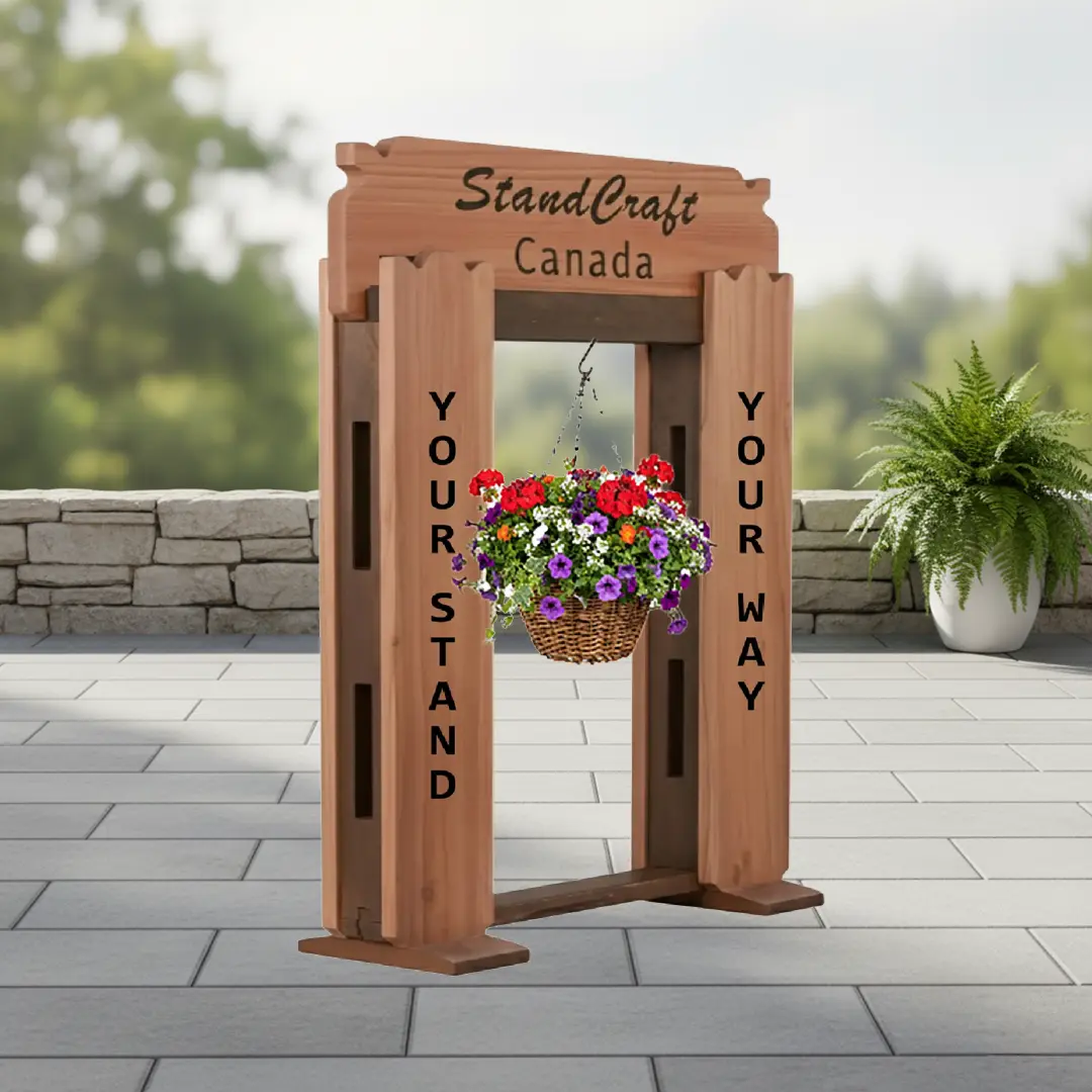 Completed cedar StandCraft Canada display stand frame shown with a colorful hanging flower basket attached, demonstrating a finished look.